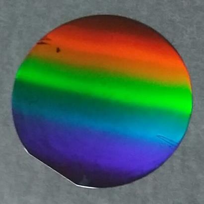 Photo of rainbow coloured wafer imprinted for photovoltaics